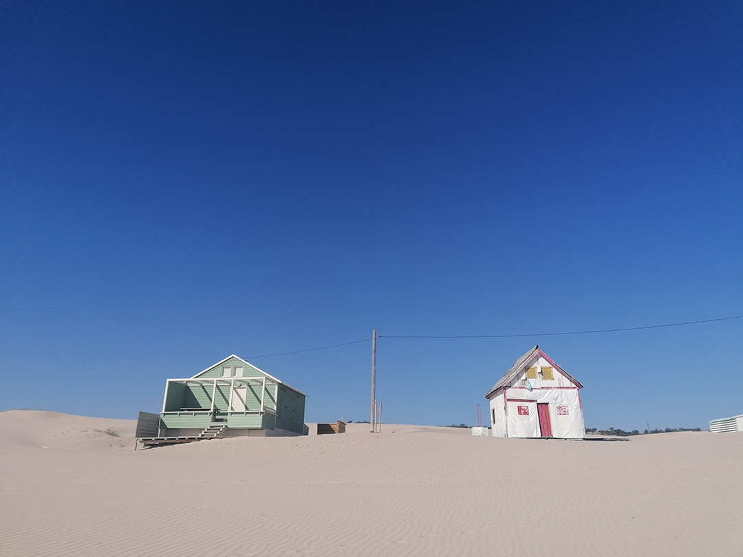 Küstenlandschaft mit traditionellen Häusern als Beispiel für das Gleichgewicht zwischen Tourismus und Natur Küstenlandschaft mit traditionellen Häusern als Beispiel für das Gleichgewicht zwischen Tourismus und Natur